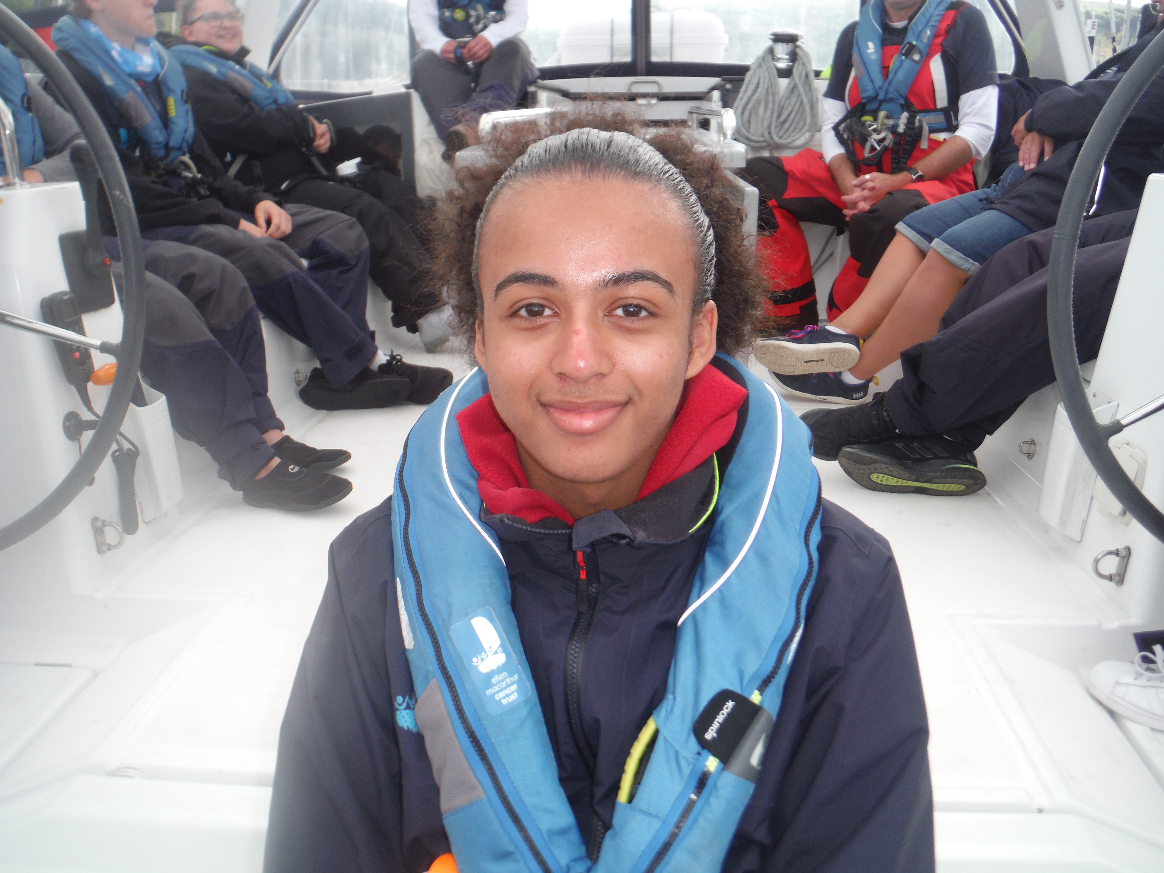 Callum sitting and smiling at the camera on the stern of Caledonian Hero 
