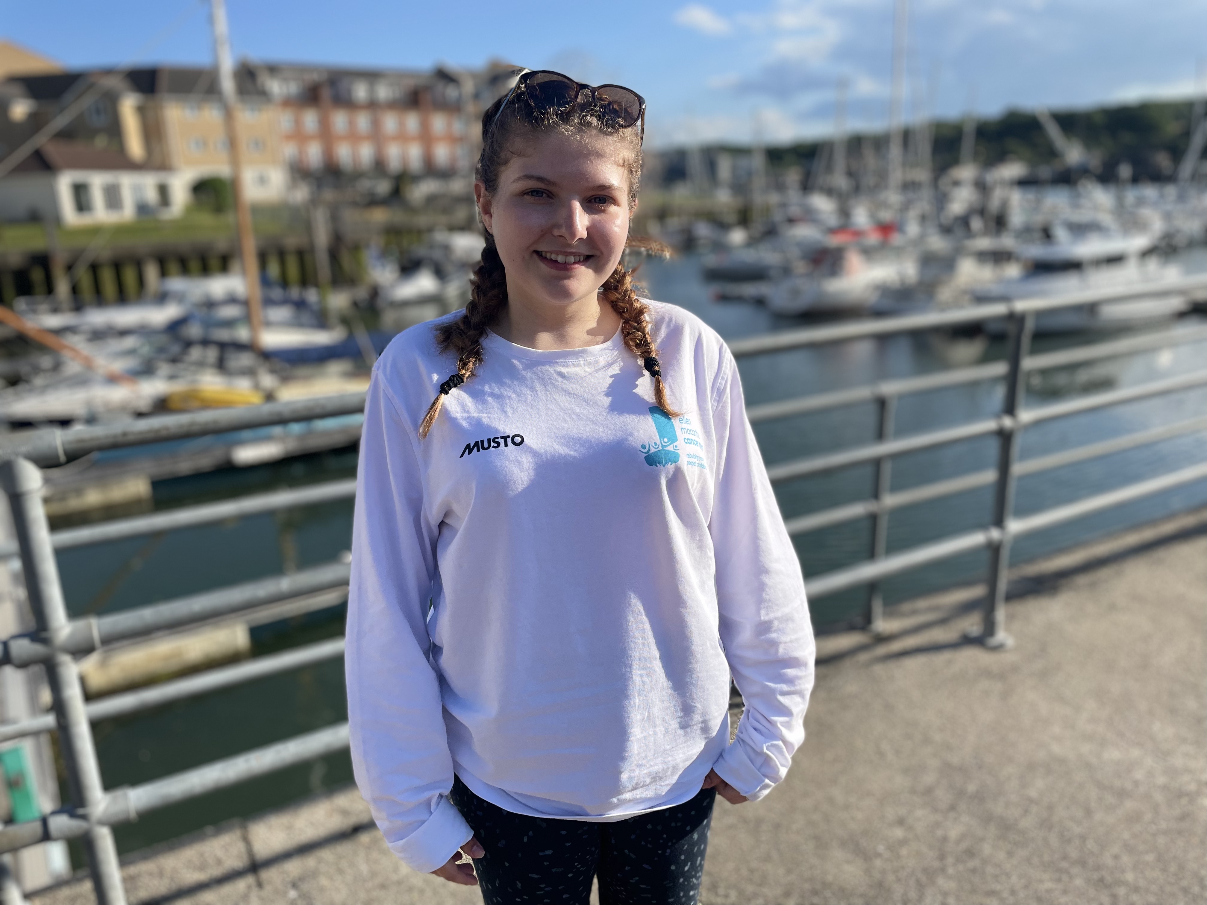 Libby standing smiling in front of East Cowes Marina on a sunny day on the Isle of Wight