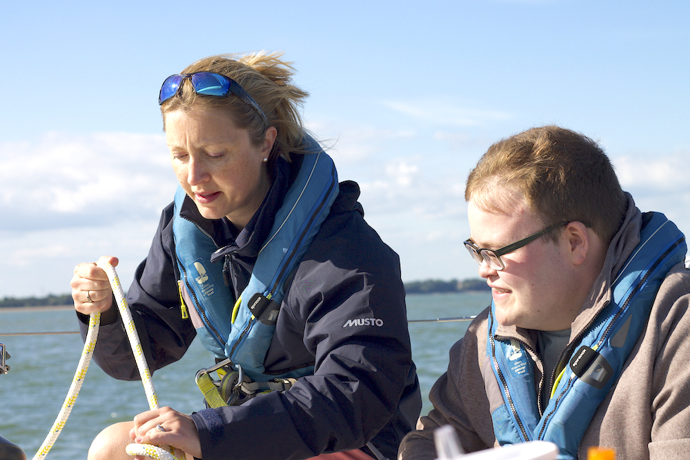 Skipper Vicky shows young person, Joe, the ropes