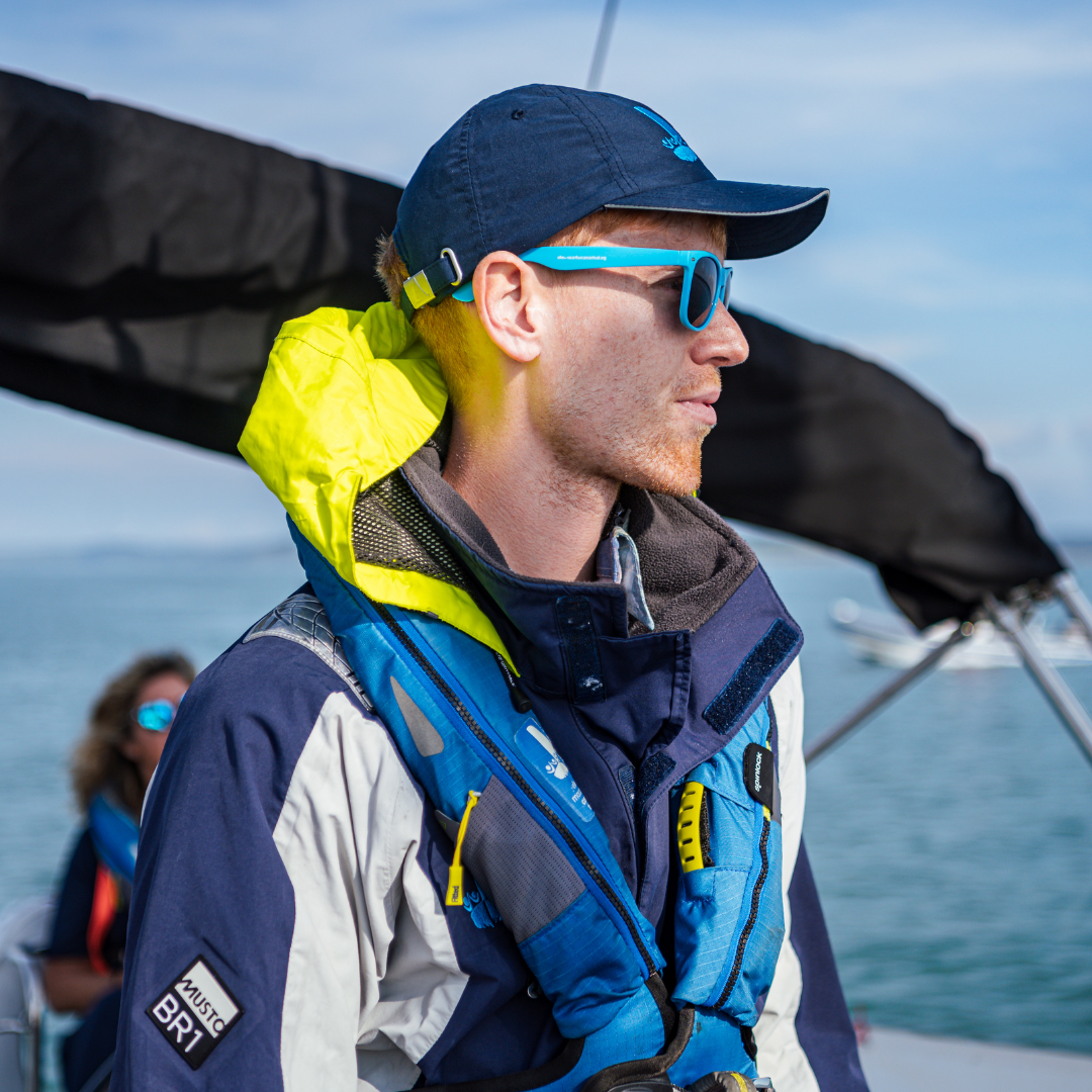 Callan Glass aboard a Trust trip wearing a navy Trust blue cap and glasses