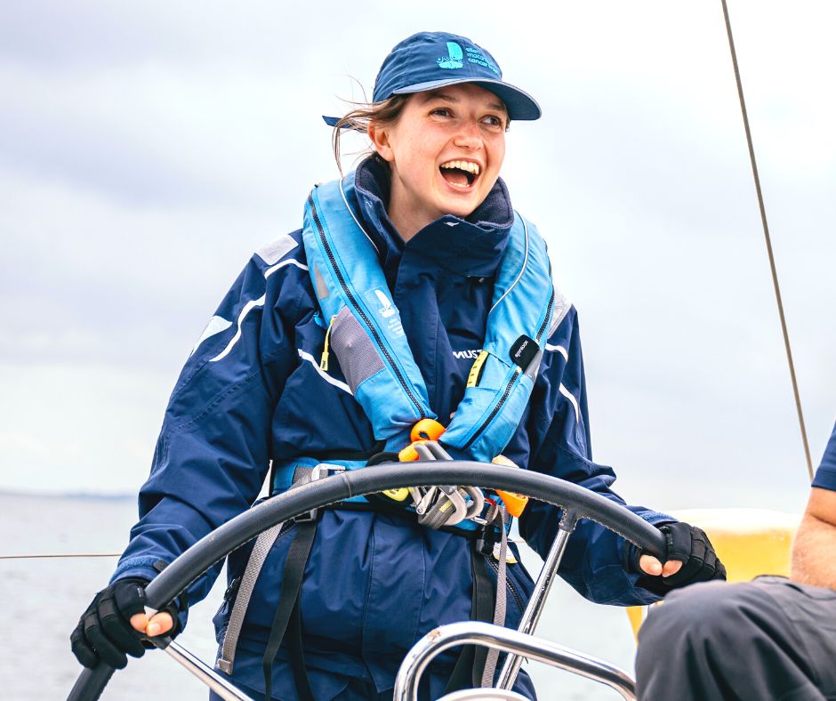 Emily Wright helming a Trust boat with a massive smile on her face